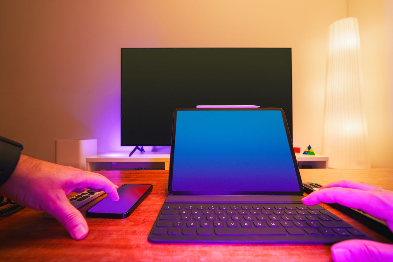 services-02 A vibrant workspace featuring a laptop, tablet, and TV with colorful lighting.